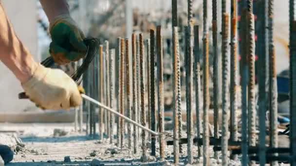 Un hombre trabaja con la construcción de metal en un sitio . — Vídeos de Stock