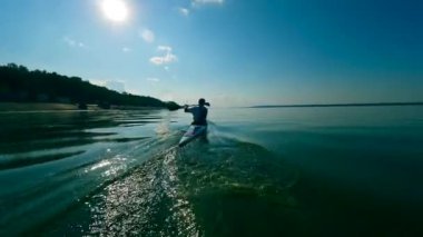 Su yüzeyini erkek bir kürekçi geçiyor.