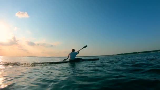 En sjö med en manlig båtsman som korsar den på en kanot — Stockvideo