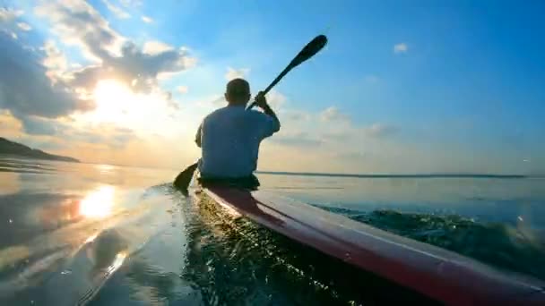 Visão traseira de um velejador macho navegando em uma canoa — Vídeo de Stock