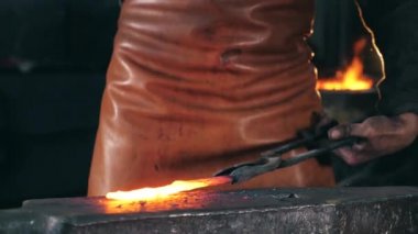 Yanar döner metal ağır çekimde dövülmektedir.