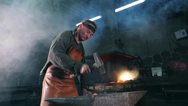 Movimiento lento de un herrero forjando metal incandescente — Vídeos de Stock