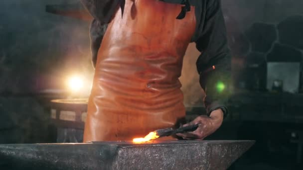 A mesterember vasszerszámot kovácsol a kovácsműhelyben. — Stock videók