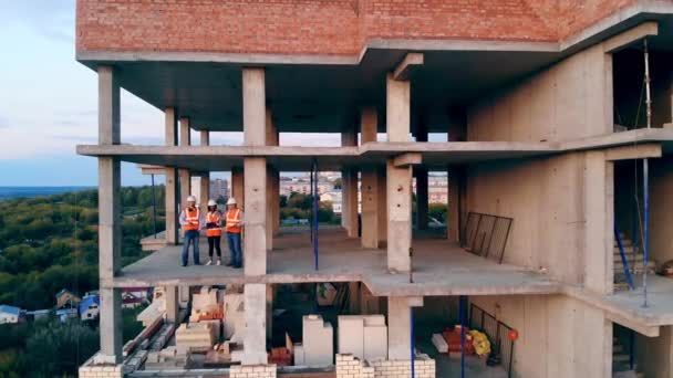 İnşaatçılar inşaat alanında konuşur, evleri kontrol ederler.. — Stok video