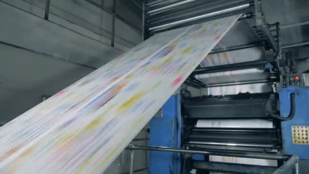 Εξοπλισμός εκτύπωσης με έγχρωμο χαρτί που κυλά κατά μήκος. Εκτύπωση εφημερίδων σε τυπογραφείο. — Αρχείο Βίντεο