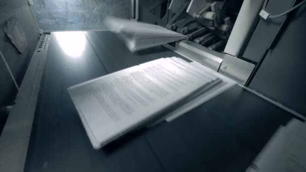 Páginas de papel impreso se mueven a lo largo del transportador . — Vídeos de Stock