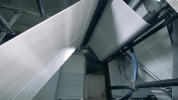 Rollo de papel se mueve a través de la máquina de impresión. Impresión de periódicos en una planta . — Vídeos de Stock