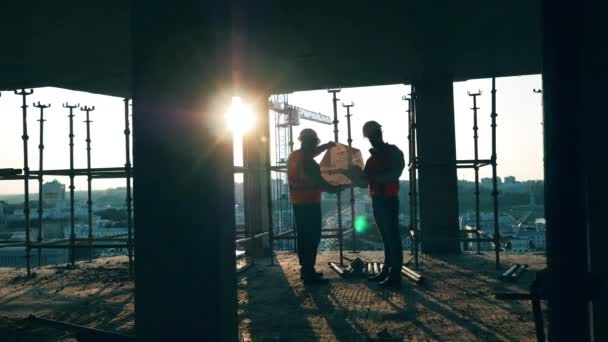 Les ingénieurs en uniforme travaillent avec un plan directeur . — Video