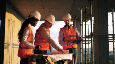 Üniformalı insanlar inşaat alanında birlikte çalışıyorlar..