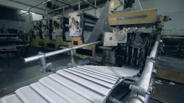 Печатные листы бумаги движутся по промышленному транспортеру — стоковое видео