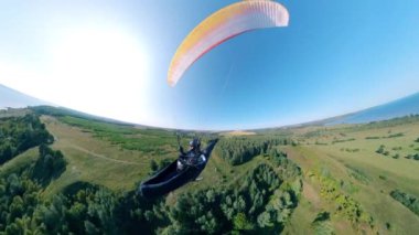 Bir insanla paraglider yer üstünde uçuyor.
