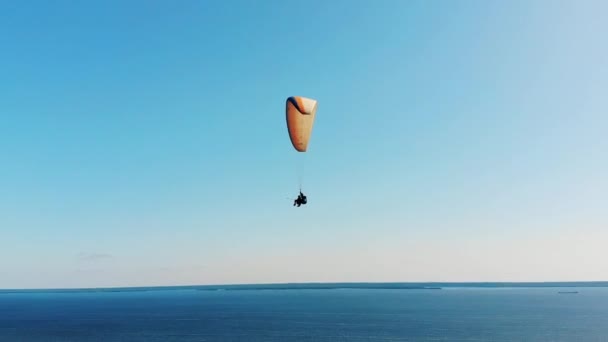 Twee mensen vliegen boven het water op de paraplane. — Stockvideo