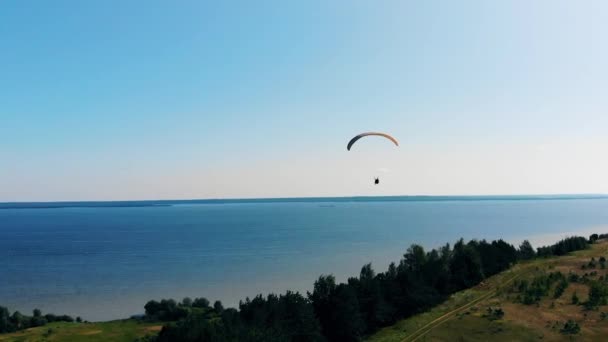 Blauwe rivier met daarboven een paar paragliding — Stockvideo