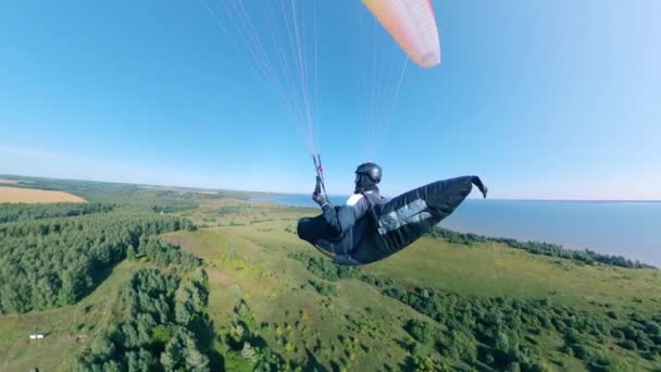 Una persona sta volando il parawing sopra i campi verdi — Video Stock