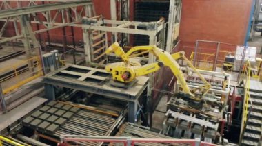 Modern robot kol endüstriyel fabrikada hareket ediyor.