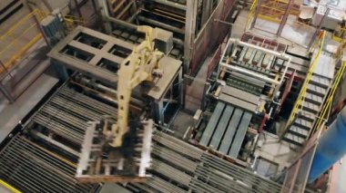 Robot bir kolun üst görüntüsü tuğlaların yerini değiştirmeye hazırlanıyor. Modern otomatik fabrika ekipmanları.