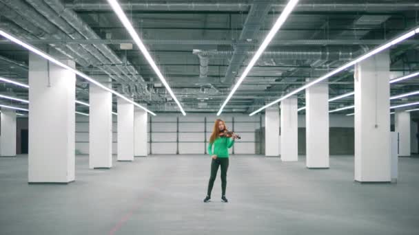 One performer plays violin in a big room, wearing casual clothes. — Stock Video
