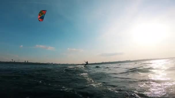 Atleet rijdt op een kiteboard op het water. Vlieger surfer kiteboarden. — Stockvideo