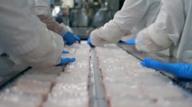 Fabrika uzmanları yengeç çubuklarını deviriyor.