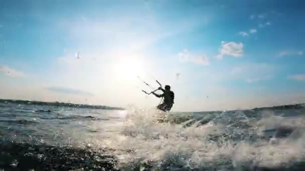 Un homme monte un kiteboard tout en s'entraînant sur l'eau . — Video
