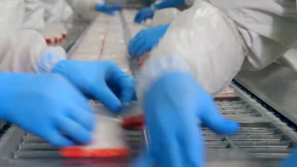 Упаковка рыбных палочек работниками завода — стоковое видео