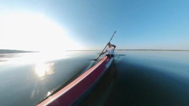 Gölde kano süren bir erkek kürekçinin ön görüntüsü.