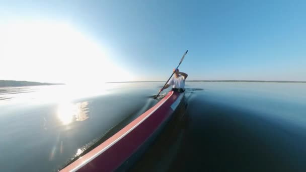 Vooraanzicht van een mannelijke peddelaar kajakken langs het meer — Stockvideo