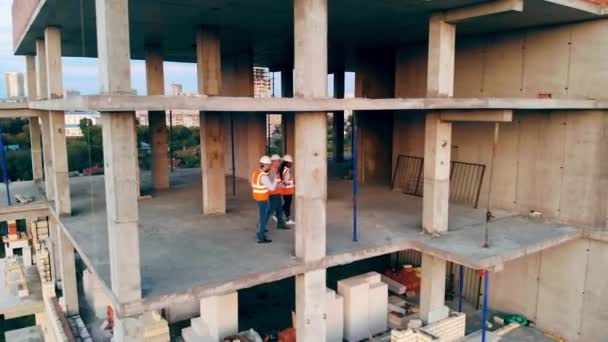 Ingenieros profesionales caminan en un edificio, comprobándolo . — Vídeo de stock