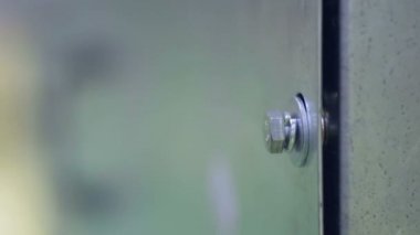 Adam endüstriyel fabrikada vida ve fındık vidaları için elektrikli alet tornavida kullanıyor..