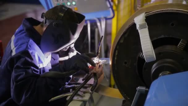 Soldador de metal de soldadura en una fábrica de producción de motores eléctricos . — Vídeos de Stock