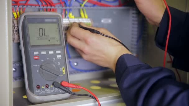 Elettricista testare energia elettrica. Tensione di prova dell'elettricista industriale della fabbrica facendo uso del multimetro allo schermo elettrico . — Video Stock