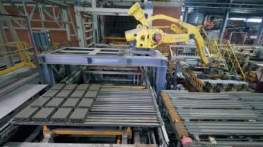 Çalışan endüstriyel makine bir taşıyıcıda çok tuğla taşır.