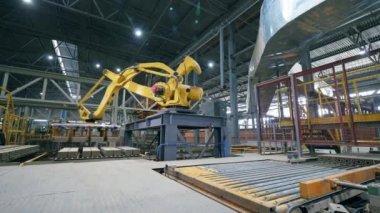 Robot makine bir fabrikada tuğla taşıyor..