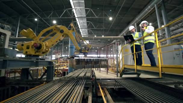 Los hombres miran una máquina de trabajo en una fábrica de ladrillos . — Vídeos de Stock