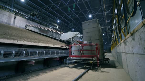 En maskin arbetar med sand och spillror på en fabrik. — Stockvideo