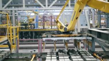Otomatik, robot makine çalışan bir taşıyıcıdan tuğlaları taşır.