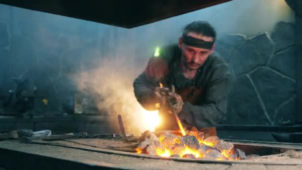 Ferreiro profissional aquece uma faca no fogo . — Vídeo de Stock