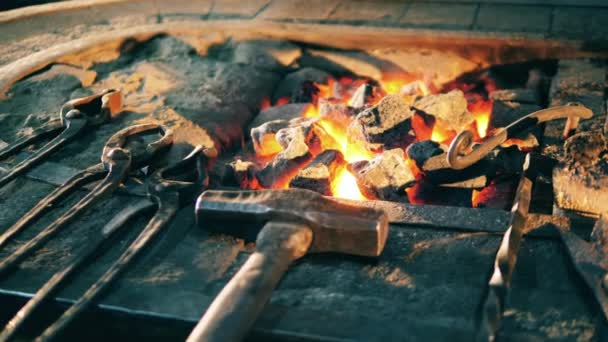 Ferramentas de trabalho perto de fogo em uma forja . — Vídeo de Stock