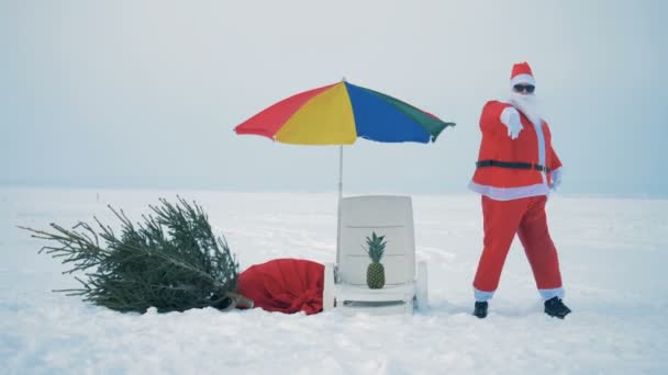 Taniec Santa Claus w pobliżu oazy plaży w śnieżnym terenie — Wideo stockowe