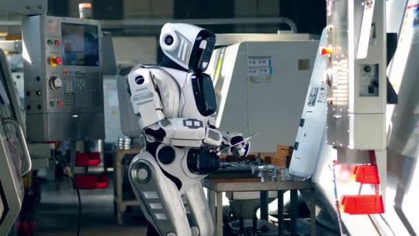 Types d'androïdes blancs sur une tablette, travaillant dans une installation . — Video