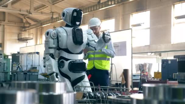O persoană verifică un cyborg de lucru într-o instalație . — Videoclip de stoc
