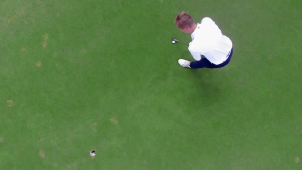 Игрок в гольф теряет лунку во время удара — стоковое видео