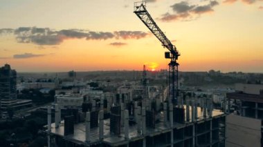 Bir vinç inşaat alanında çalışıyor, bir ev inşa ediyor..