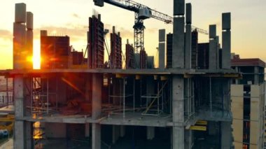 Günbatımı arkaplanındaki tamamlanmamış bina ve vinç.