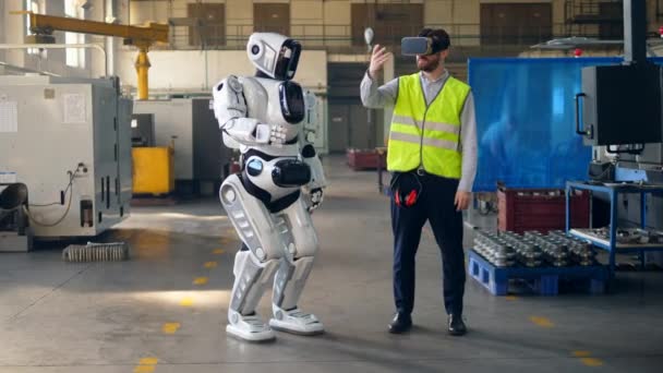 Male engineer wears VR glasses to control a robot. — Wideo stockowe