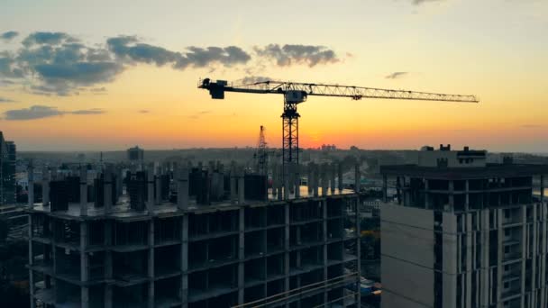 Site de construction avec grue bleue de travail sur fond de coucher de soleil . — Video