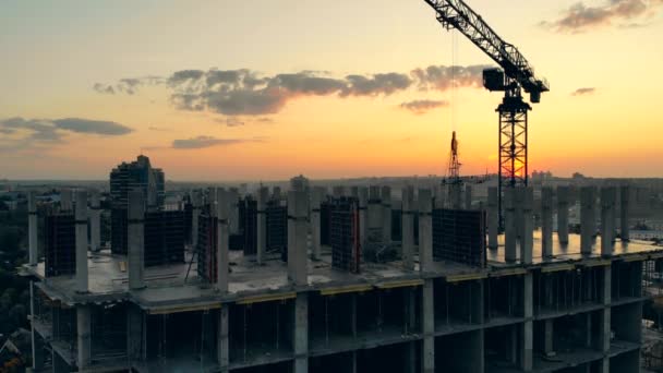 Working crane on site on sunset background. — Stock Video