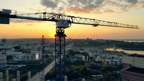 Blauer Kran auf einer Baustelle im Sonnenuntergang. — Stockvideo