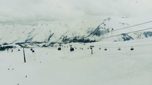 Seilbahn mit Kabinen in den verschneiten Bergen. Skilift in den Bergen. — Stockvideo