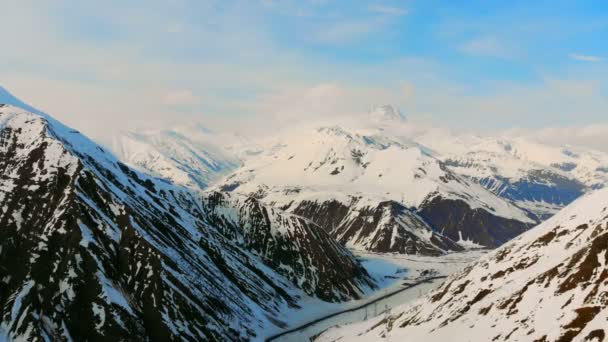 Wolkenverhangener blauer Himmel und schneebedeckte Berggipfel — Stockvideo